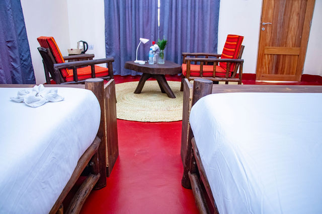 Guest room with twin beds and a warm seating corner